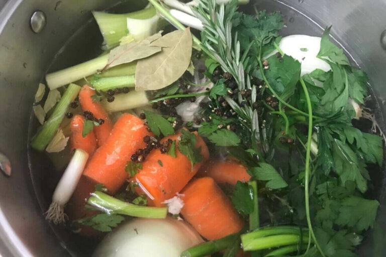 veggies and herbs in a pot.