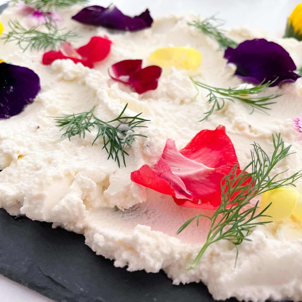 slate board with whipped feta and fresh flowers