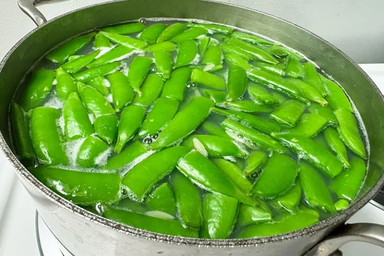 green snap peas in simmering water.