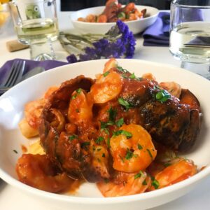 a bowl of spaghetti squash with seafood marinara on a dinner table.