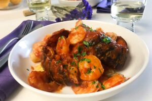 a bowl of spaghetti squash with seafood marinara on a dinner table.