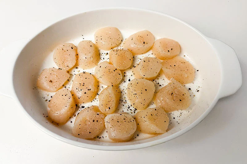 raw scallops in baking dish