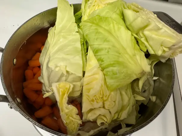cabbage and carrots cooking in pot.