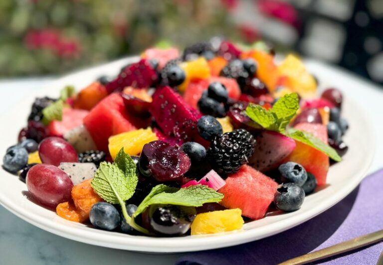 Exotic fruit salad with honey and lime dressing on a platter.