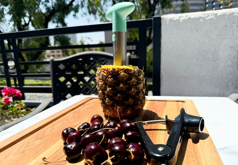 pineapple corer and cherry pitter with fruit.