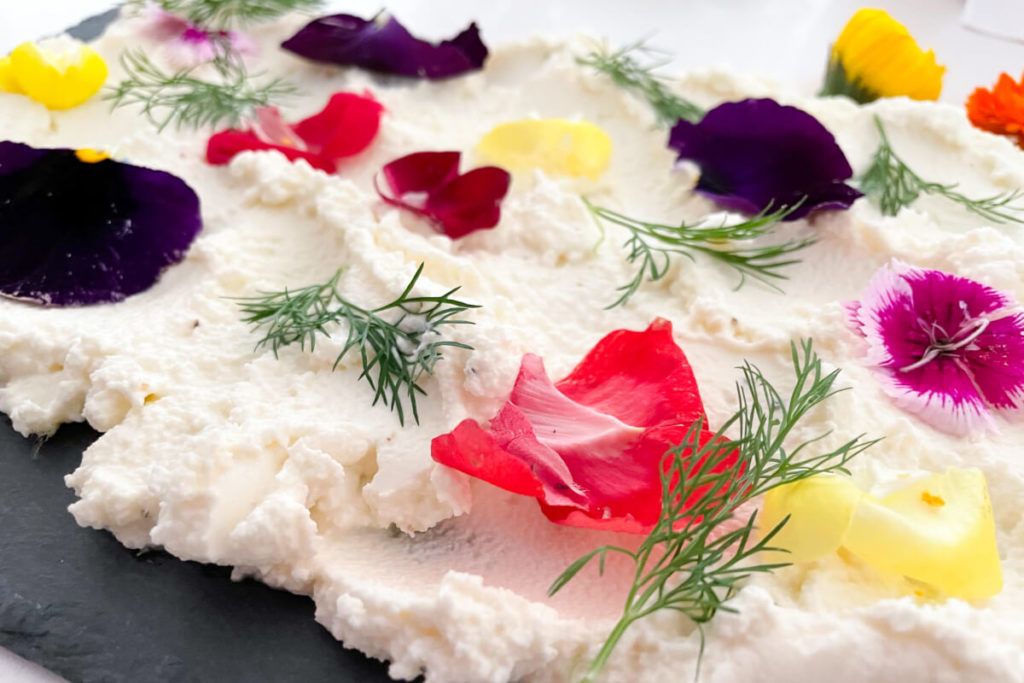 Whipped Feta garnished with fresh flowers and herbs.