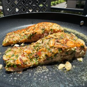 almond crusted salmon cooking in skillet.