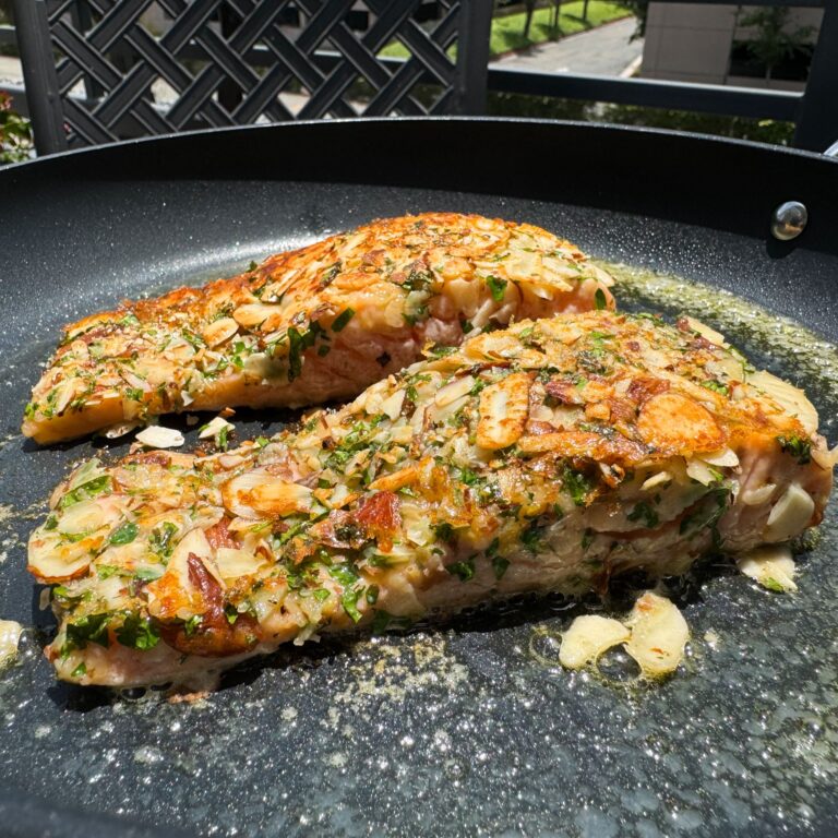 almond crusted salmon cooking in skillet.