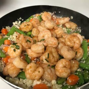 shrimp added to skillet with veggies and nuts.