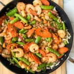 Sweet and Spicy shrimp on cauliflower rice in a skillet.