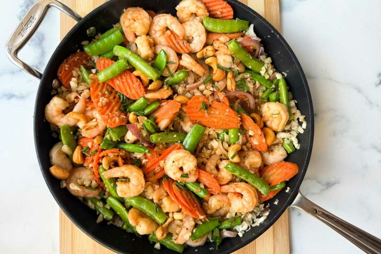 Sweet and Spicy shrimp on cauliflower rice in a skillet.