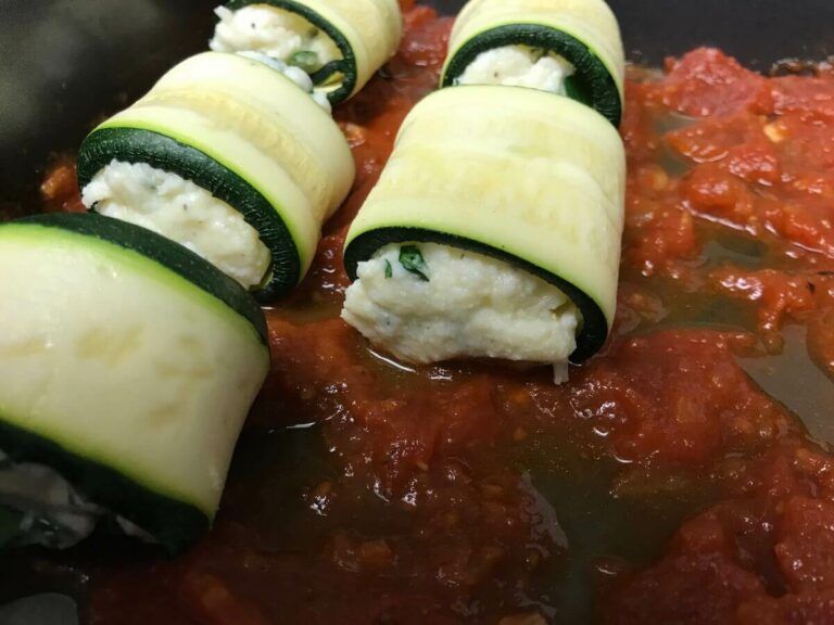 zucchini bundles sitting on sauce in the pan
