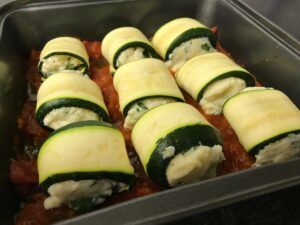 a full pan of zucchini roll ups in the pan