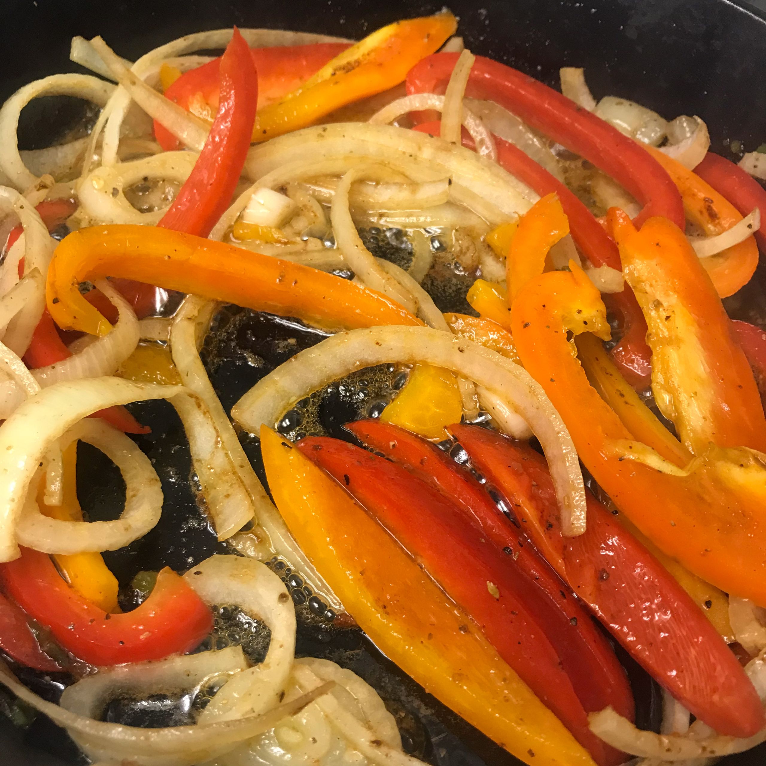 cooking peppers and onions in a skillet