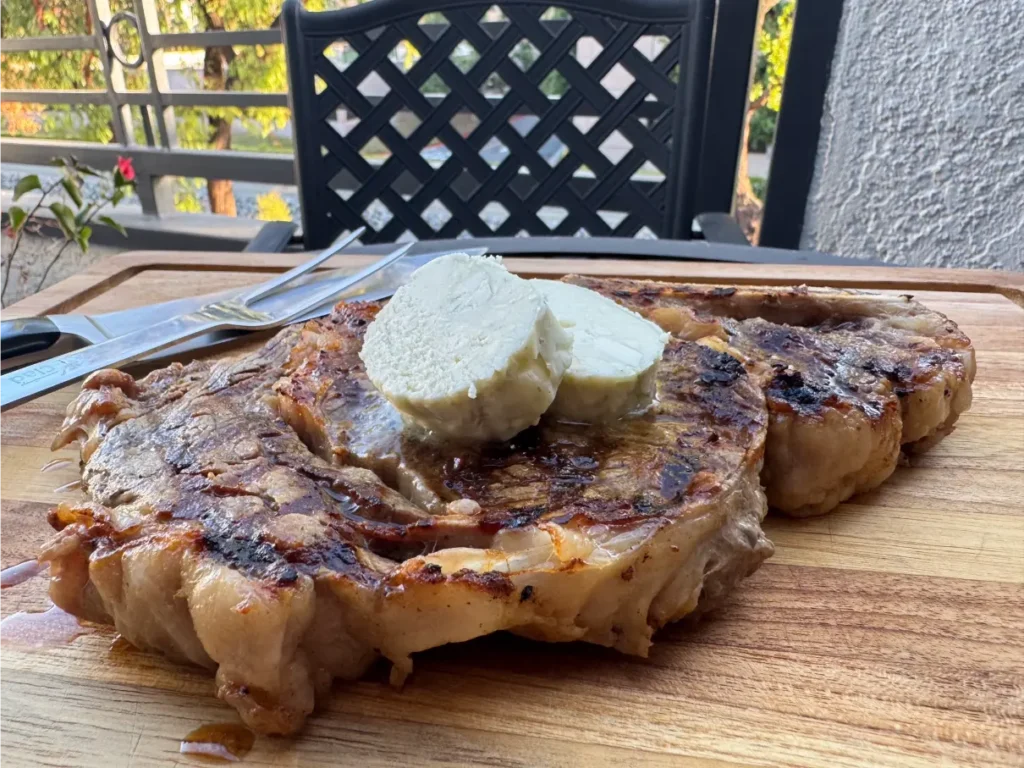 grilled steak topped with slices of creamy cheese.
