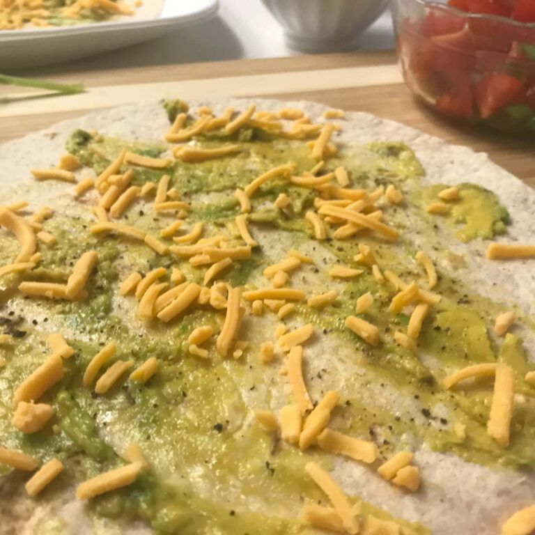 tortilla spread with avocado and cheese