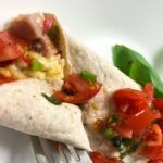 egg and ham wrap topped with tomatoes