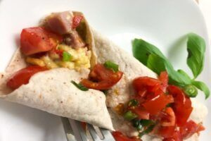 egg and ham wrap topped with tomatoes