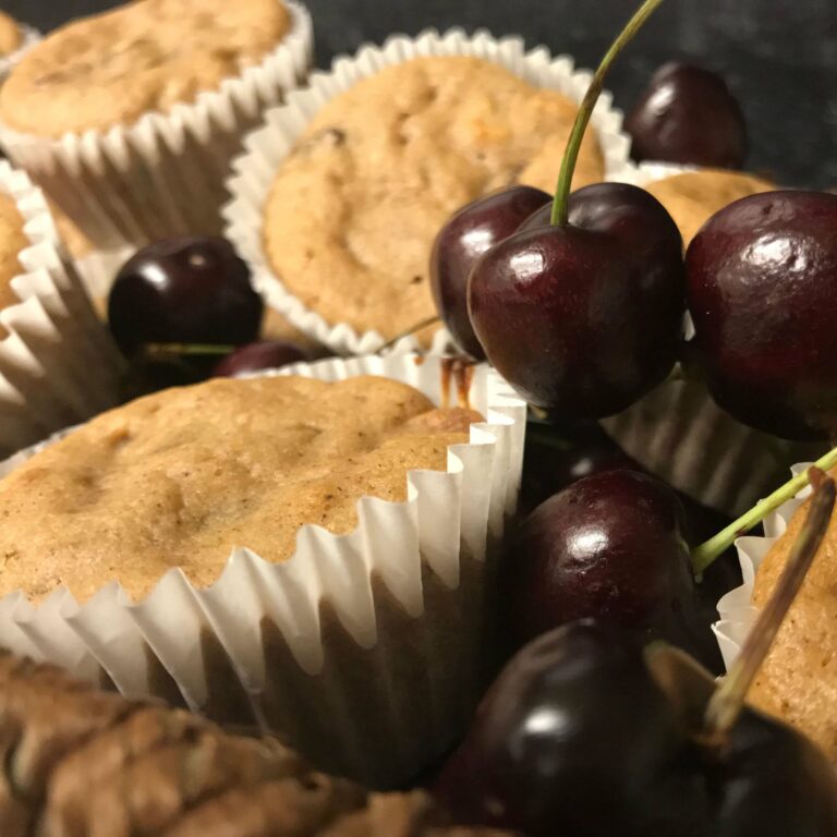 basket of baked muffins and fresh cherries.