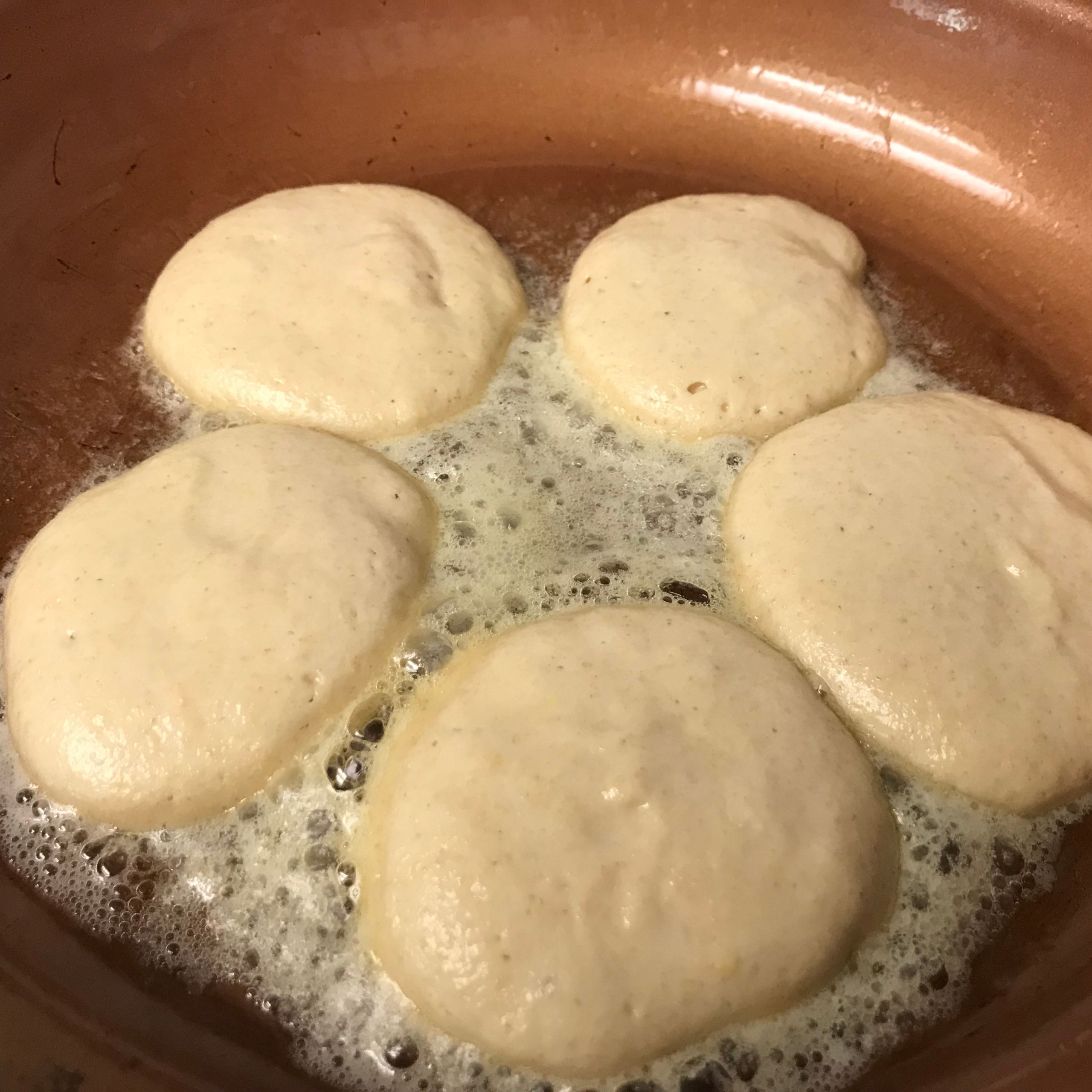 mini pancakes cooking in a skillet