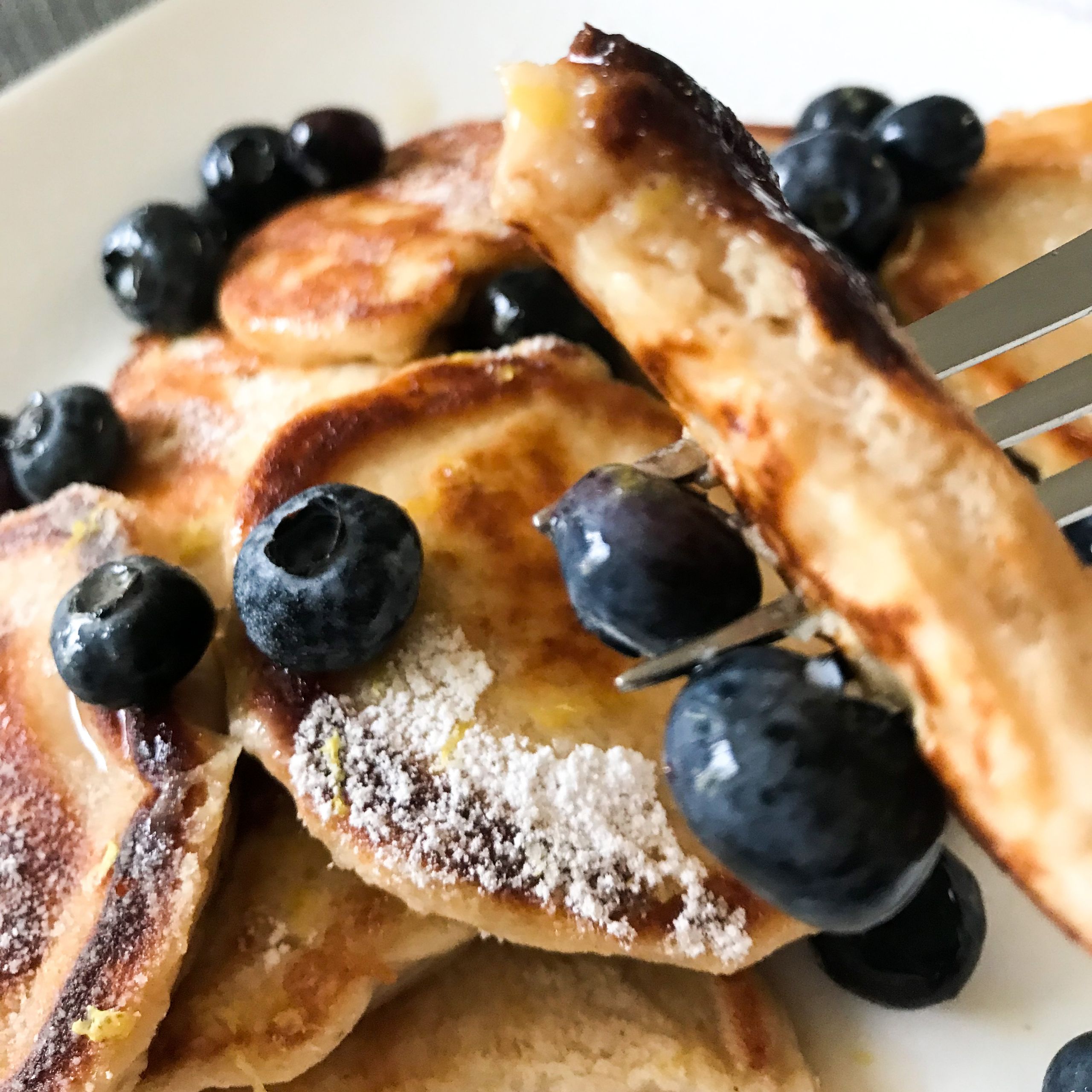 forkful of pancakes, syrup and berries