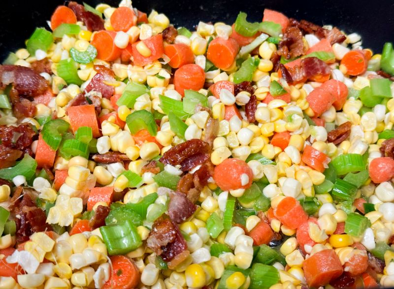 veggies and bacon cooking in pot.