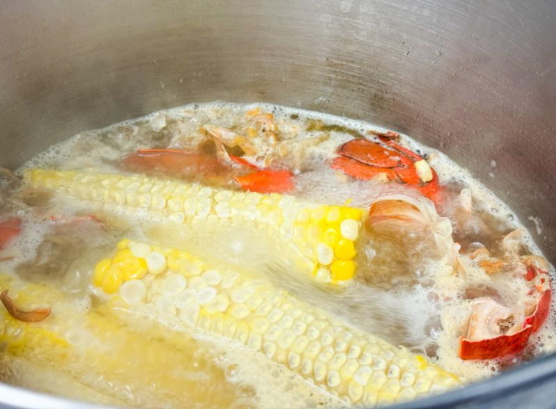 corn shellfish shells and stock cooking in pot.