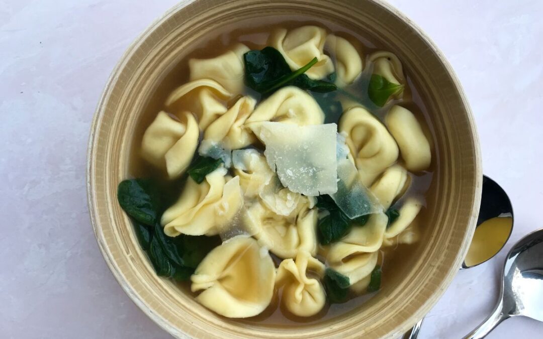 spinach and cheese tortellini soup in a bowl
