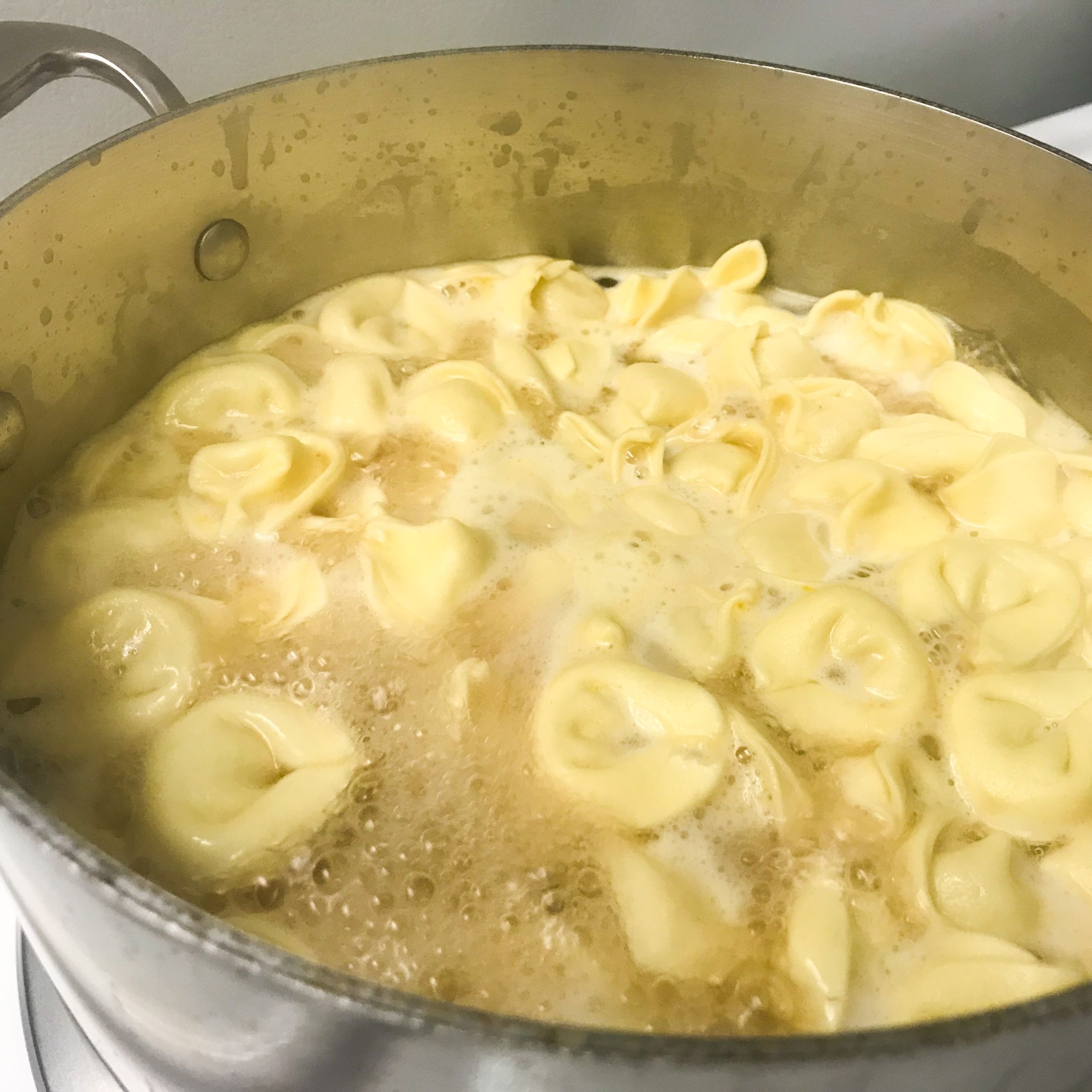 cheese tortellini cooking in a pot of water