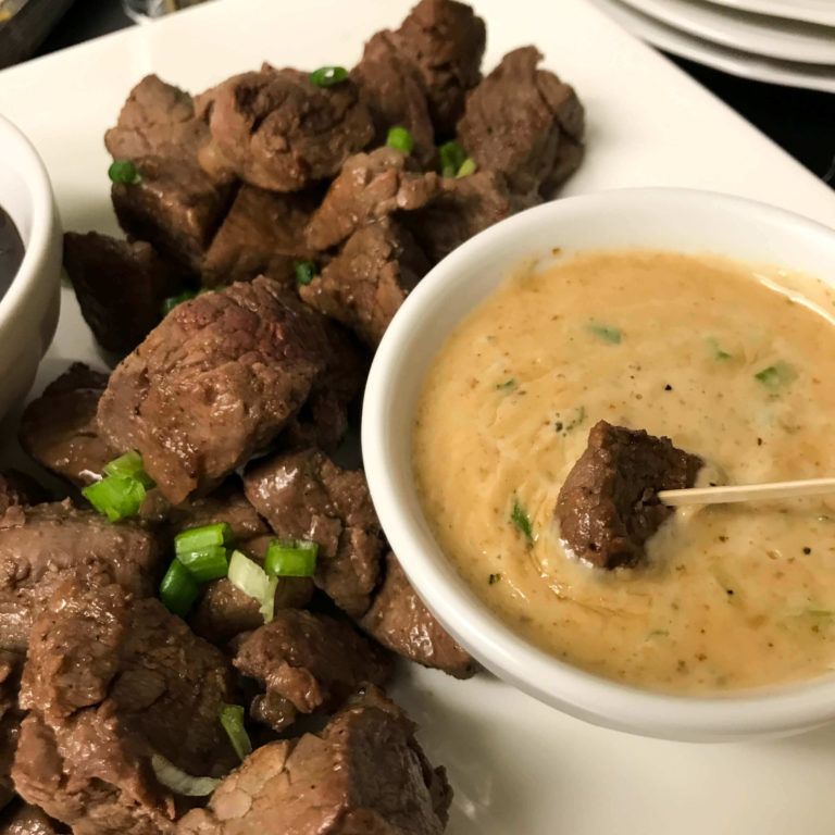 steak filet bites on a platter with dipping sauces.