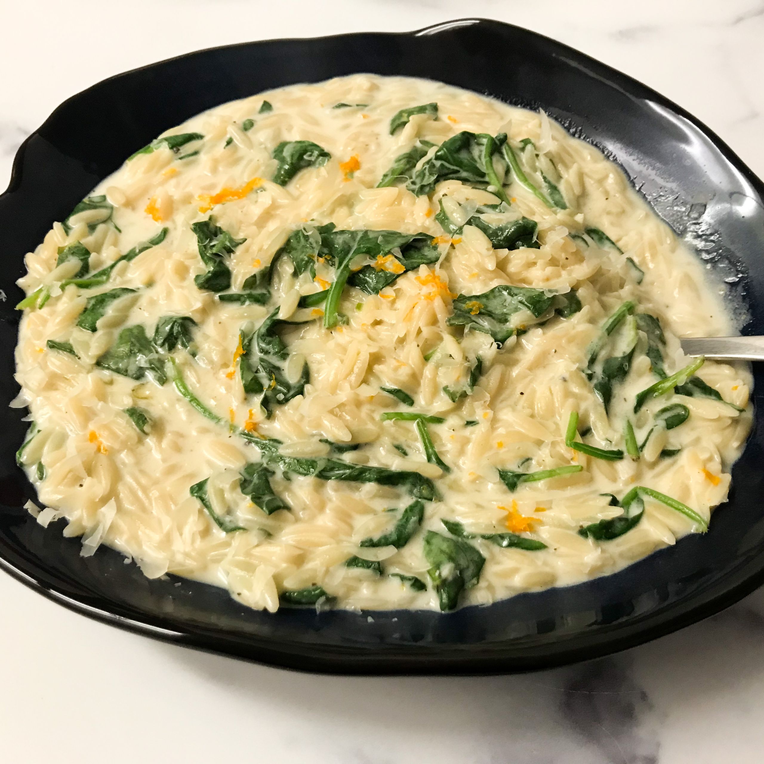 whole wheat orzo with orange and spinach in bowl | mycuratedtastes