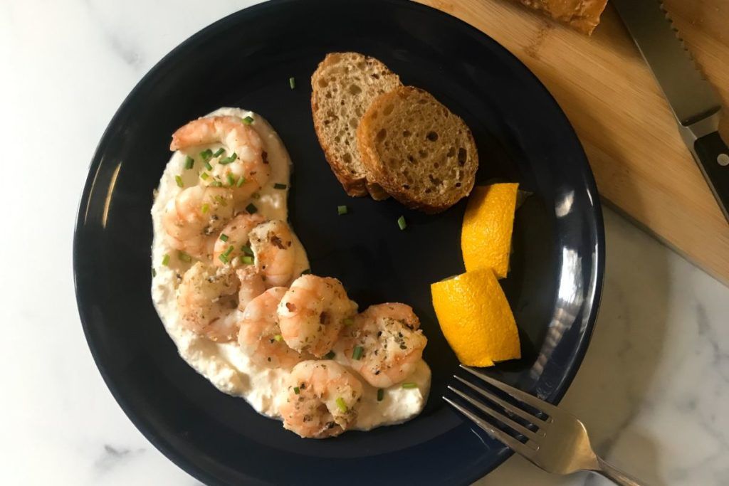 Greek shrimp with feta sauce and bread on a plate.