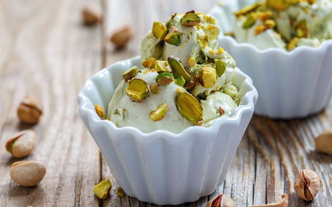 Bowls of pistachio ice cream with nuts on top