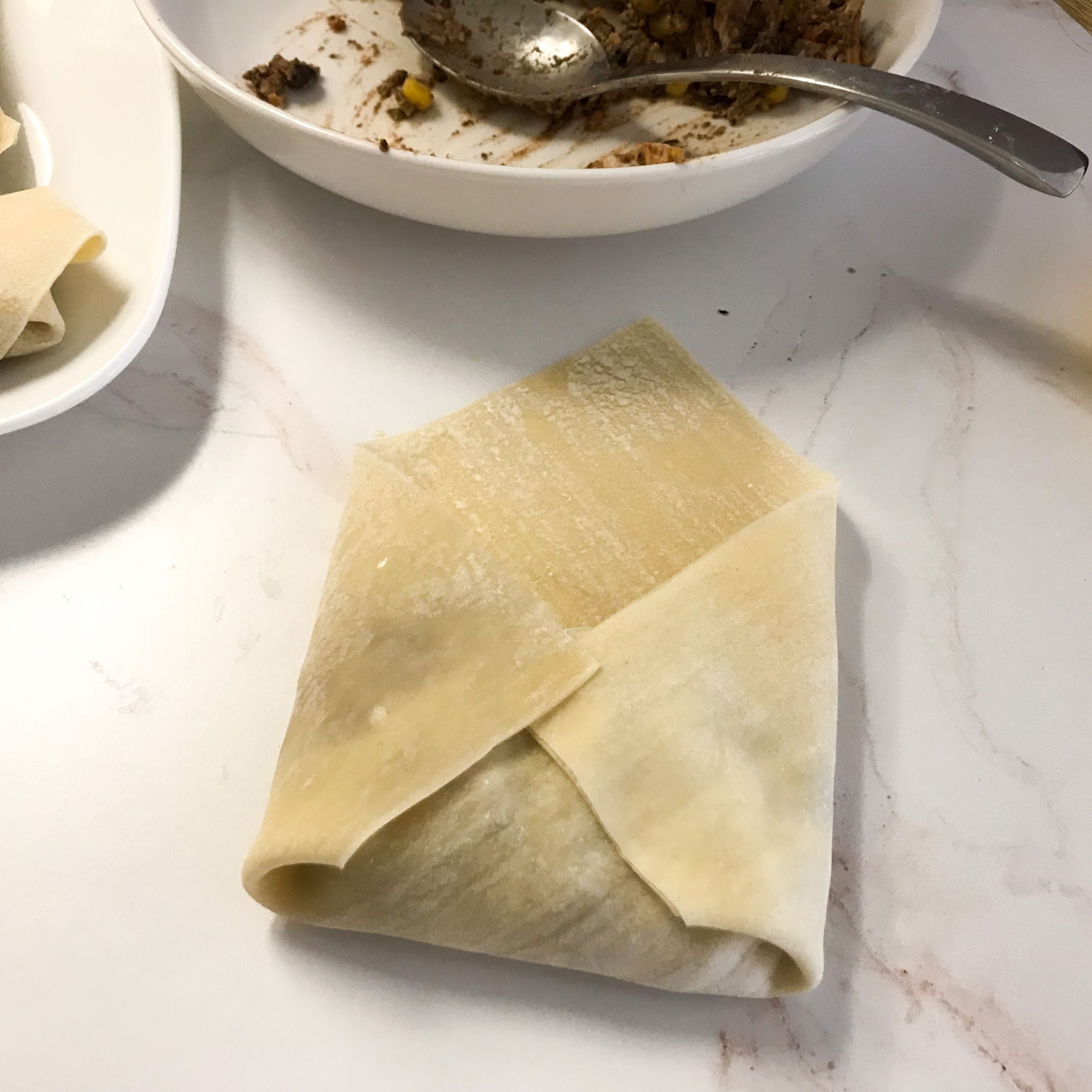 two sides of egg roll wrapper folded over filling | my curated tastes