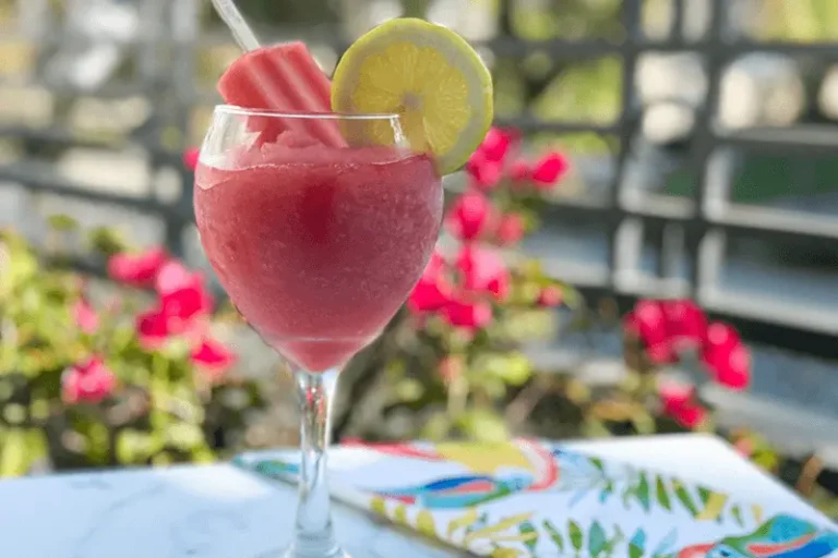 a glass of watermelon rose slushy with ice pop.