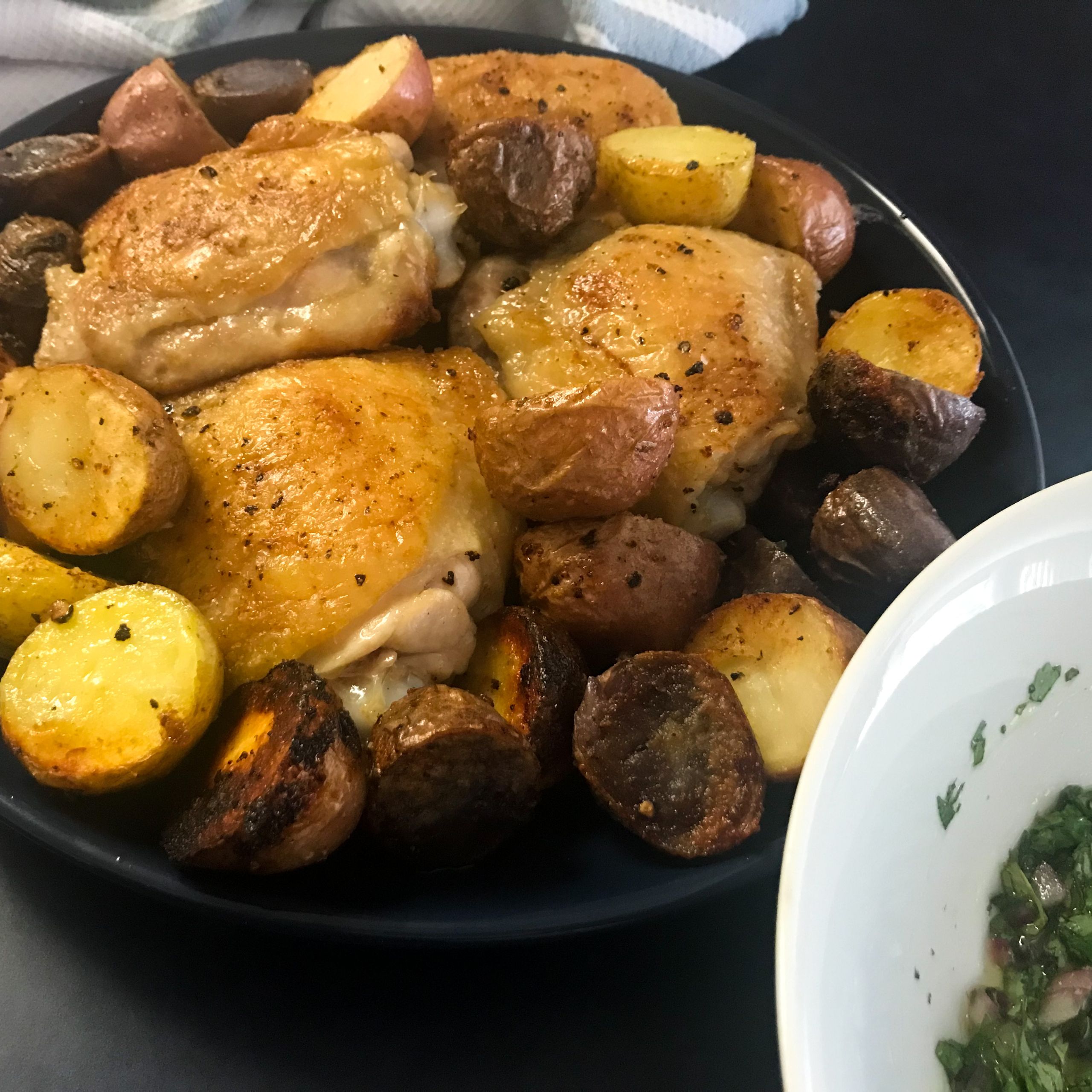 plated chicken and potatoes next to bowl of chimichurri | My Curated Tastes