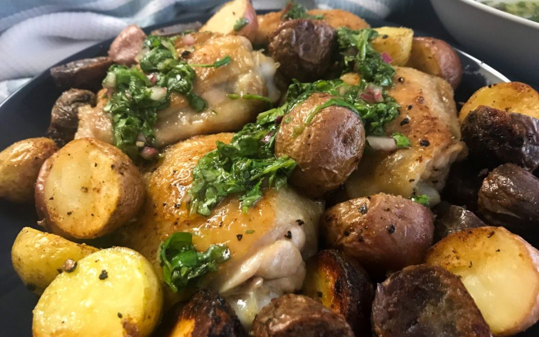 cast iron chicken with baby potatoes and chimichurri sauce in skillet | My Curated Tastes