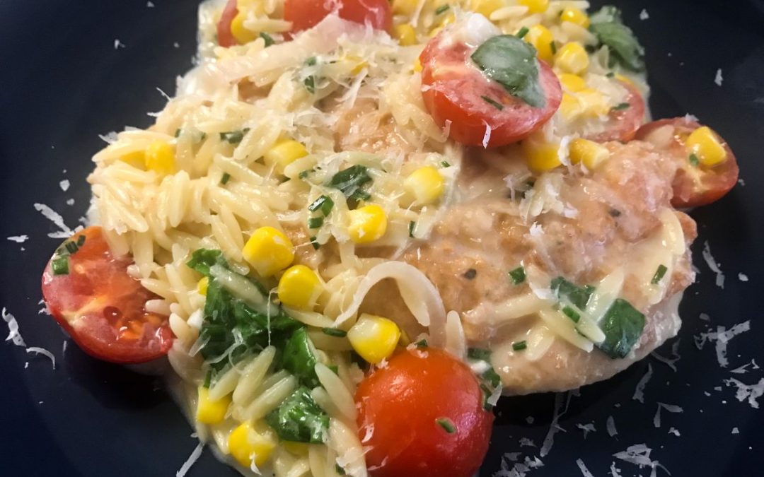 plate of creamy summer chicken with tomatoes, corn and orzo
