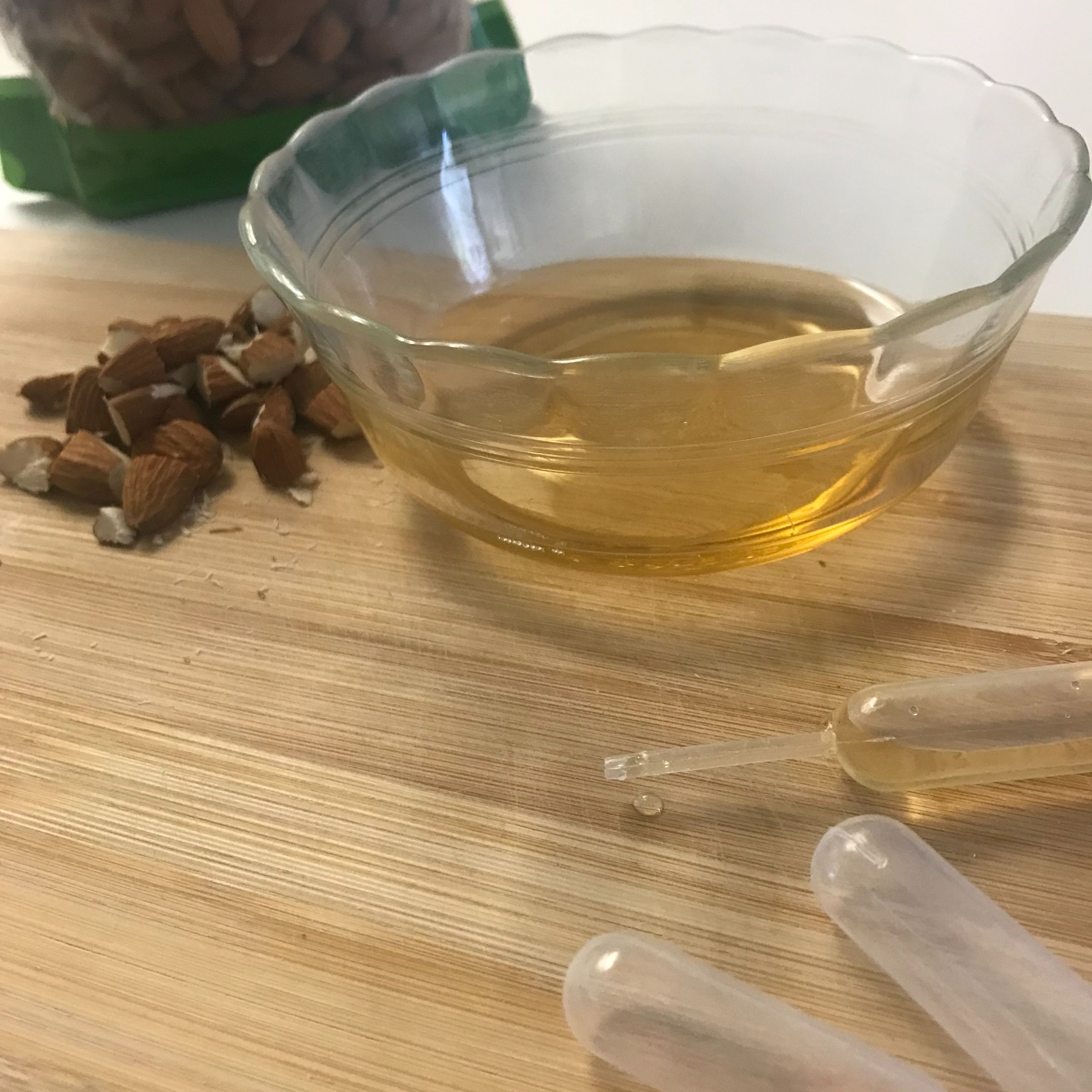 amaretto in a dish, chopped almonds and plastic syringes
