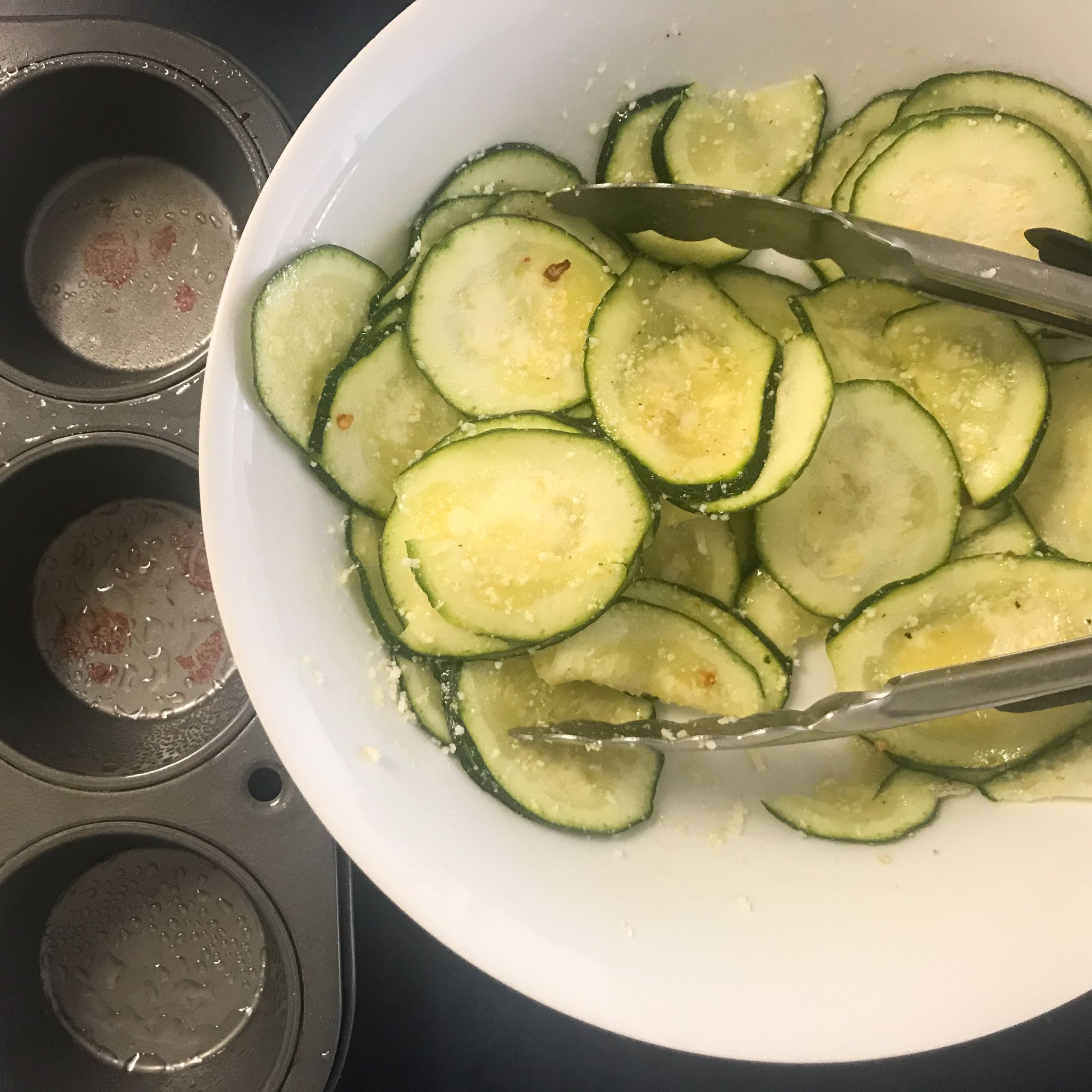 sliced zucchini mixed with ingredients in a bowl
