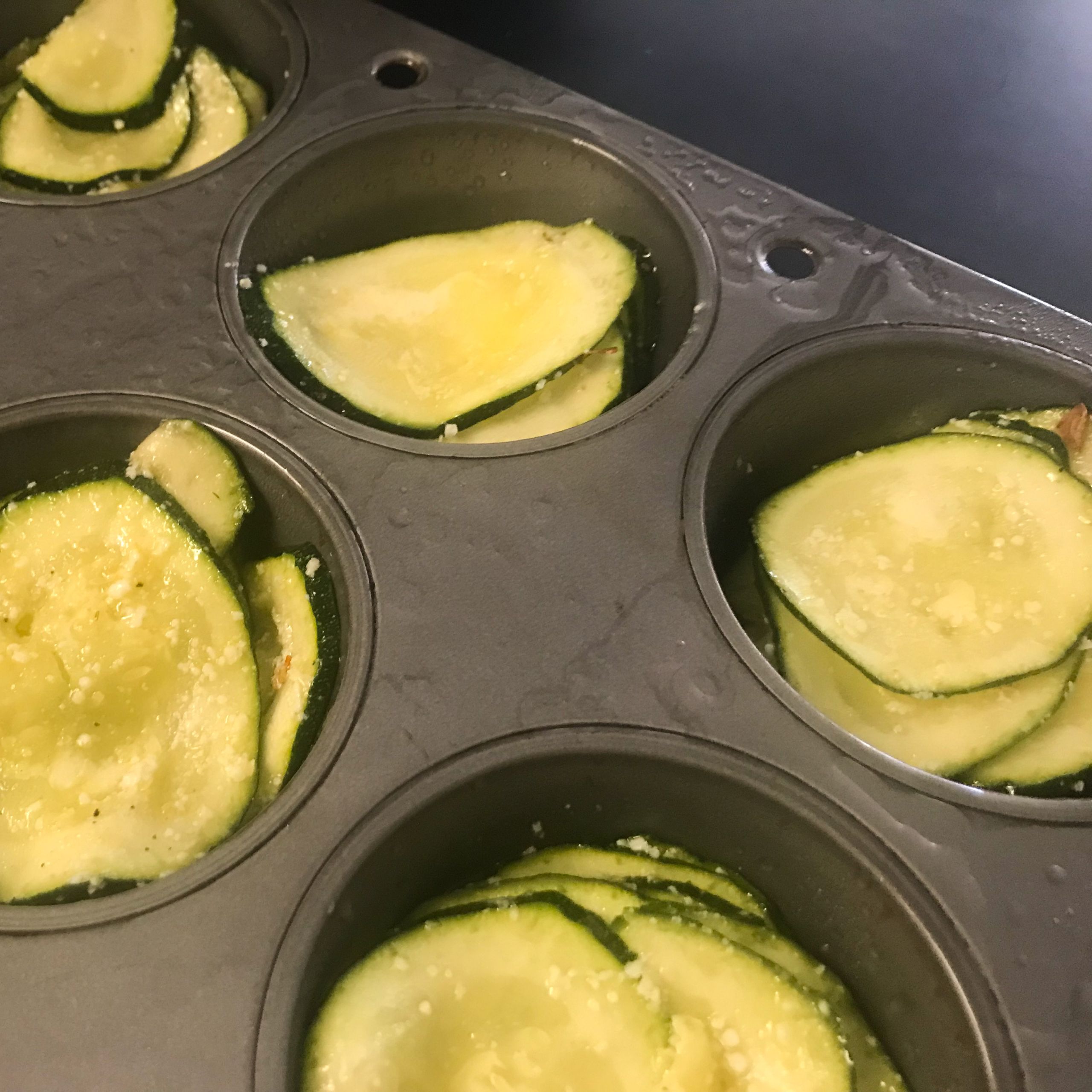 sliced zucchini in muffin tin
