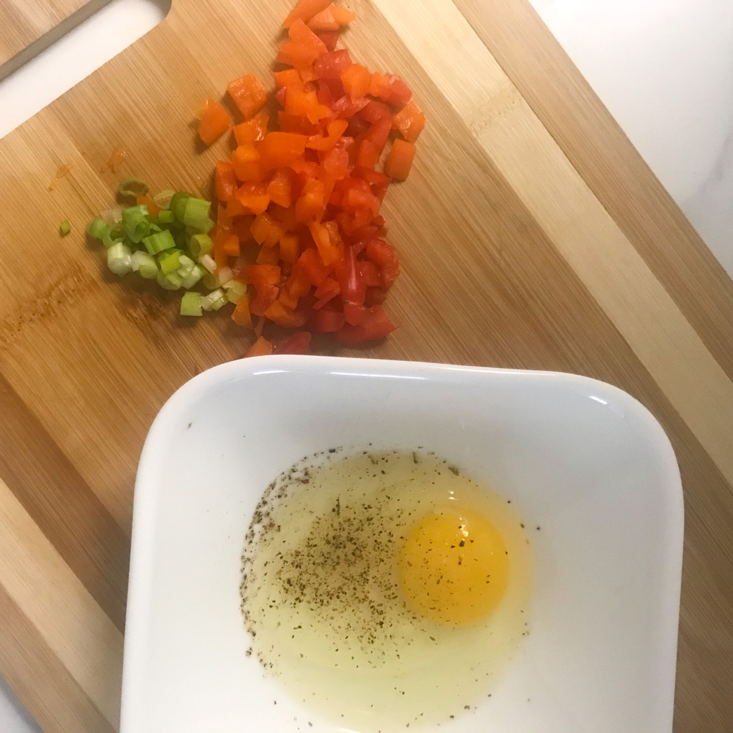 chopped peppers and onion and egg in a bowl