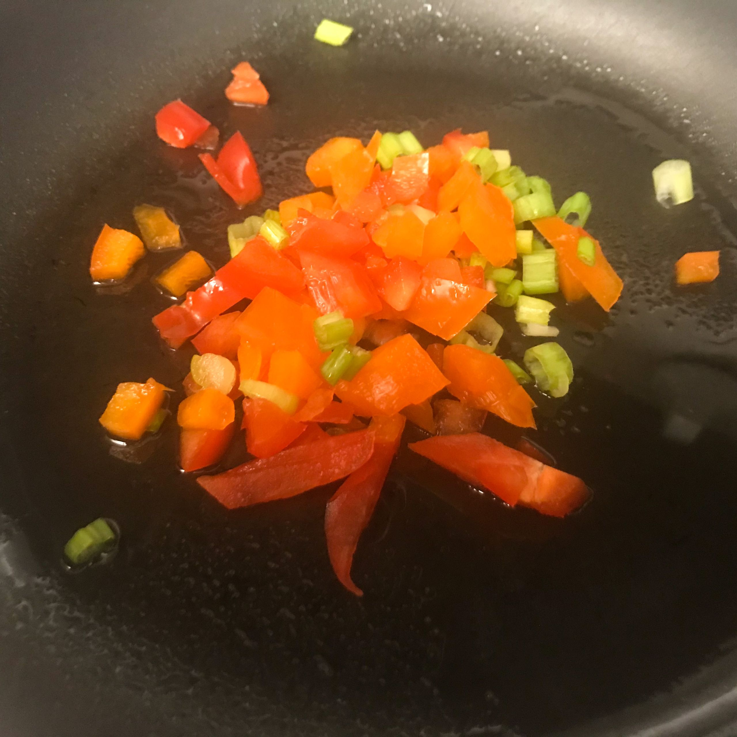 cooking peppers and onion in a skillet