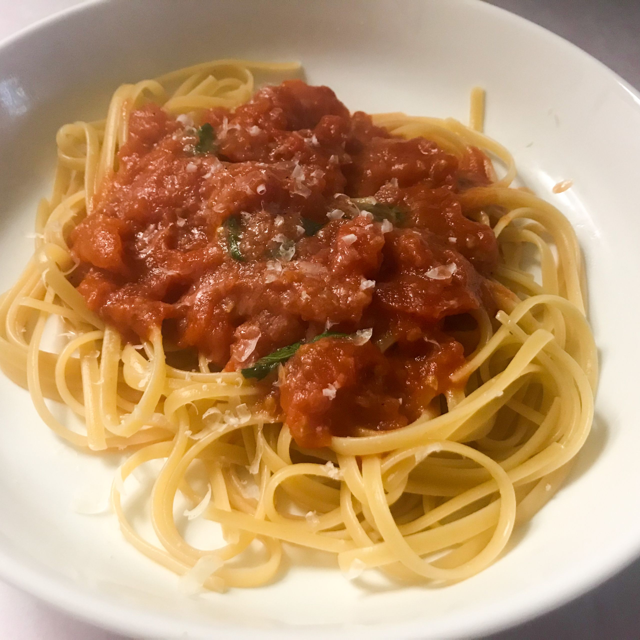 bowl of spagetti topped with tomato butter sauce