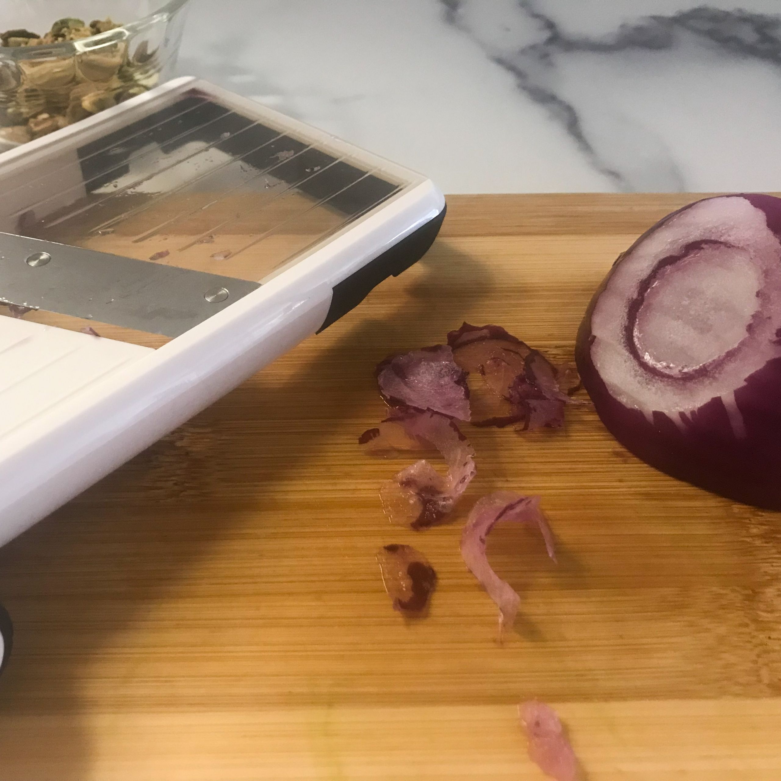 mandoline, red onion and sliced red onion on a board