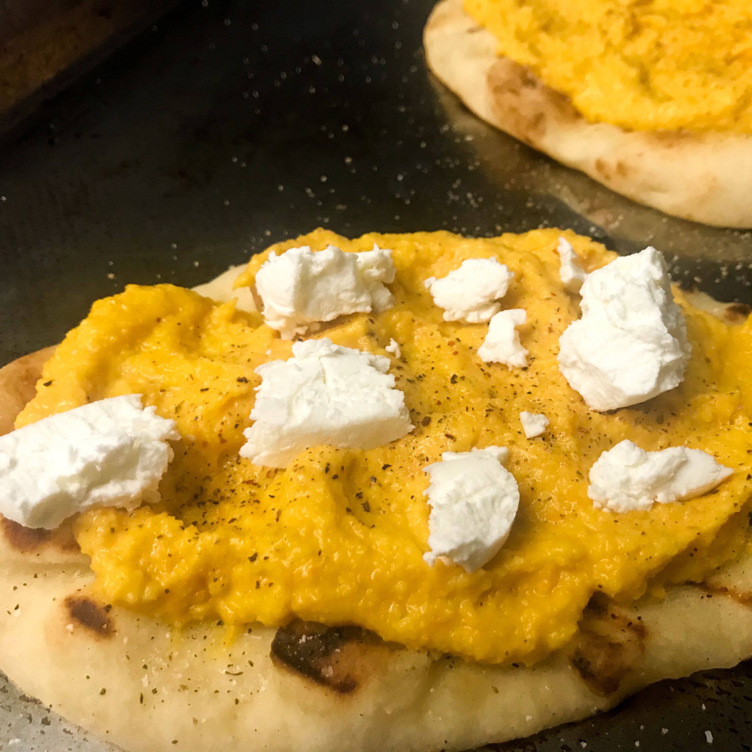 naan bread topped with vandouvan puree and goat cheese