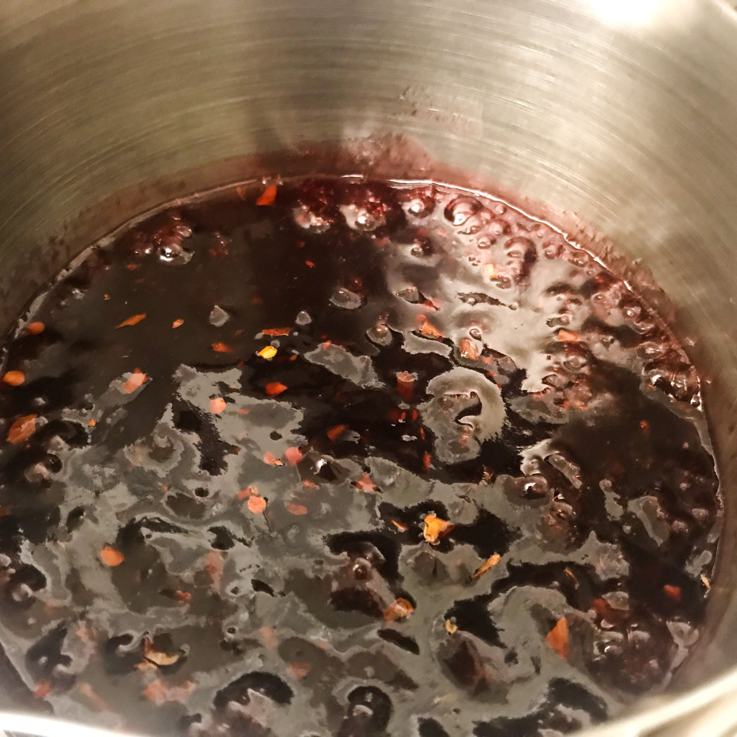 pot of raspberry preserves and chili flakes on the stove