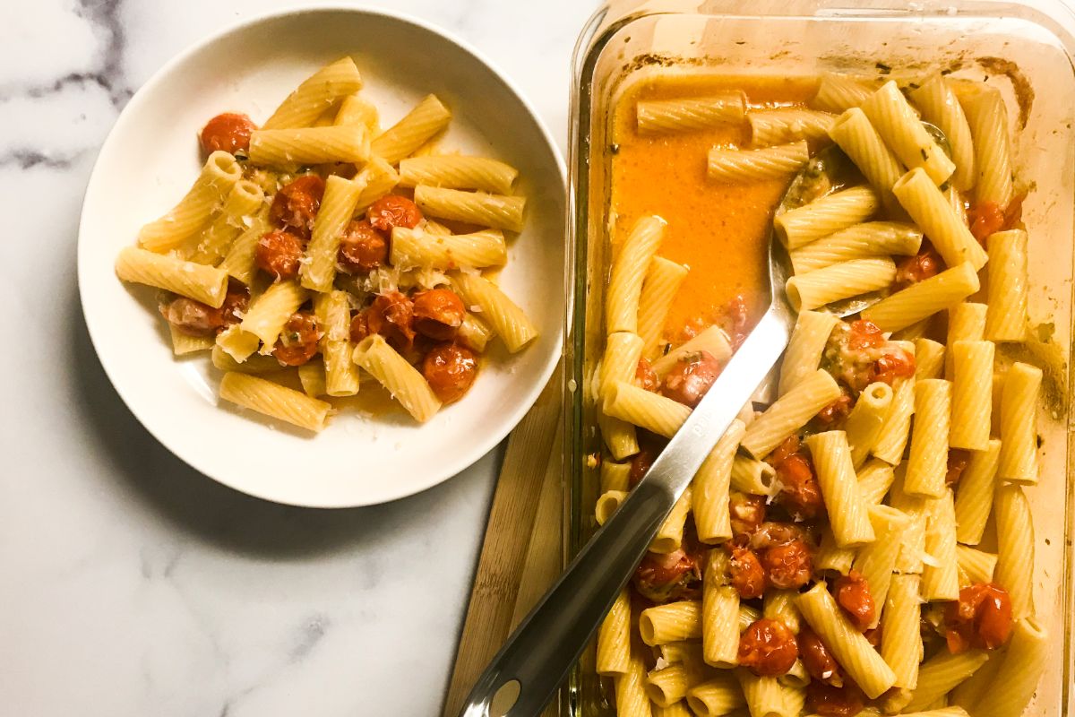 bowl of pasta next to baking dish of mozzarella cherry tomato rotini