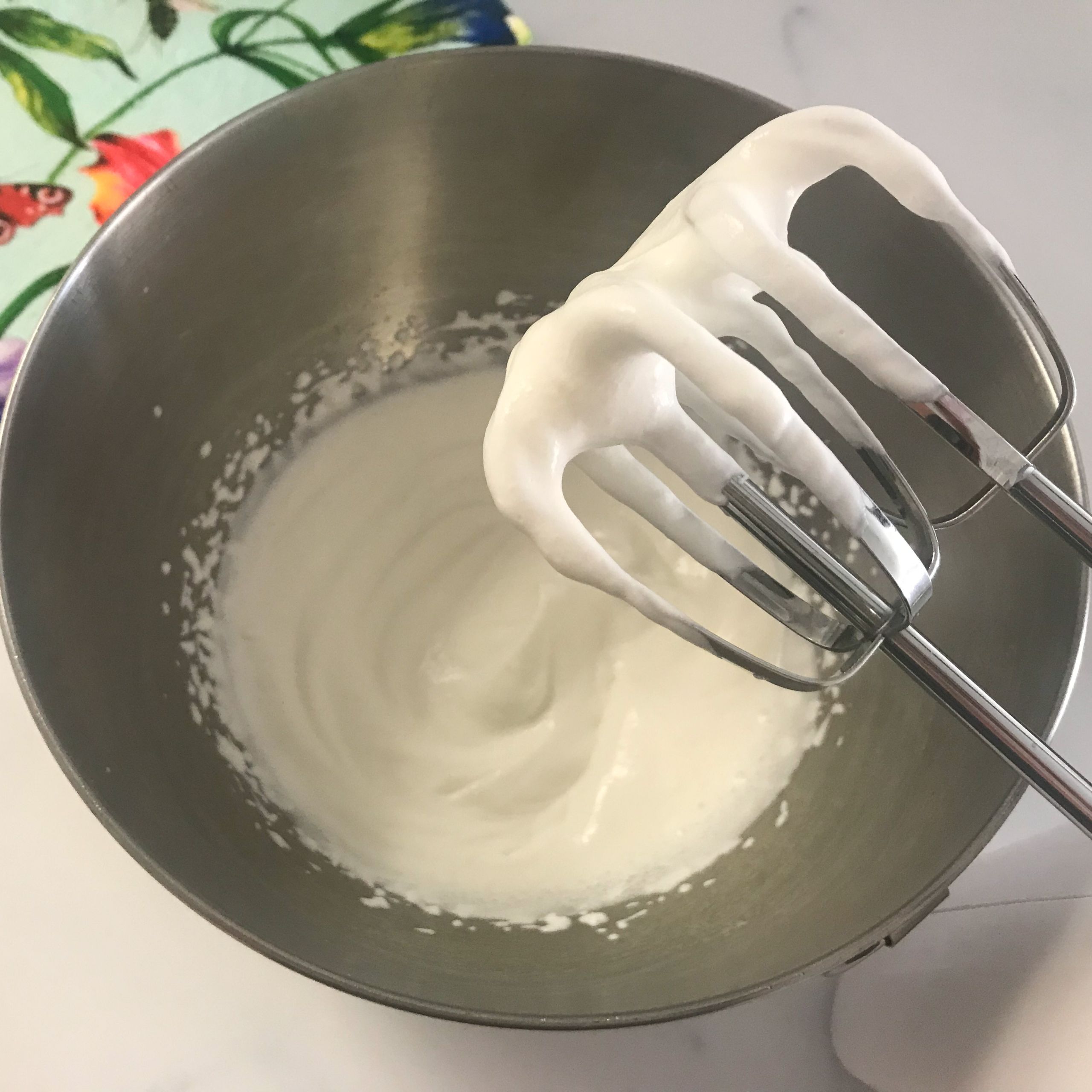 bowl of whipped cream with beaters