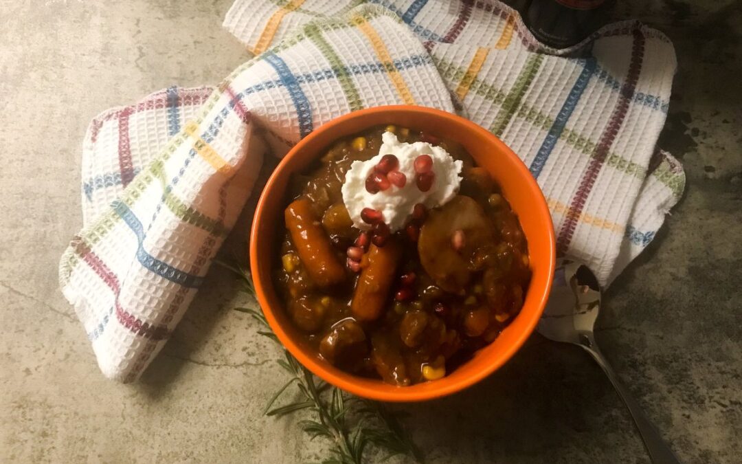 Bowl of Rosemary and Pomegranate Beef Stew topped with yogurt and pomegranate seeds